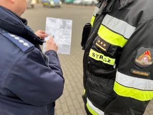 stojący na przeciwko siebie policjant ze strażakiem