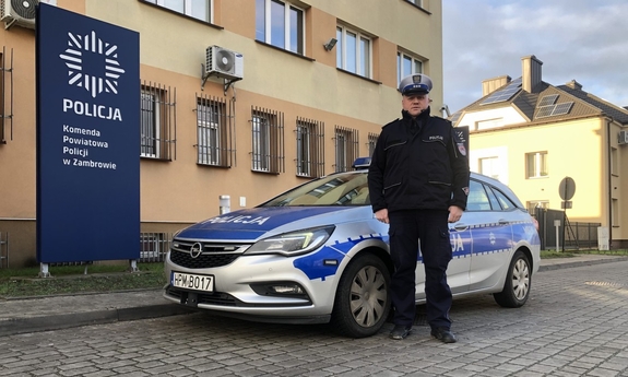 policjant stoi przy radiowozie