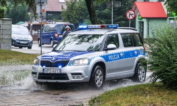 zdjęcie poglądowe, zaparkowany radiowóz a w tle pojazdy jadące ulicą