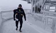 mł.asp. Paweł Molenda podczas biegu na drodze zasypanej śniegiem, wokół widać oprószone śniegiem drzewa