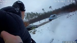 zatrzymany mężczyzna a w tle widoczne stojące w poprzek drogi auto i policyjny furgon. Wszędzie jest pełno śniegu