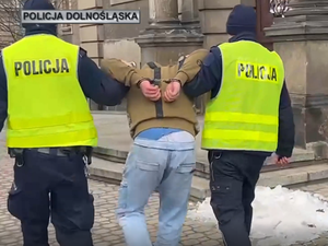 dwaj policjanci prowadzą zatrzymanego