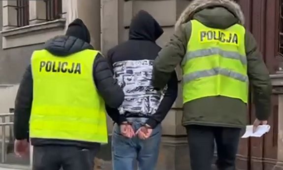 dwaj policjanci prowadzą zatrzymanego