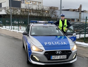 policjant stoi przy radiowozie