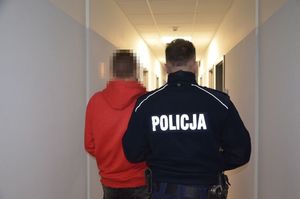 umundurowany policjant prowadzi zatrzymanego nastolatka