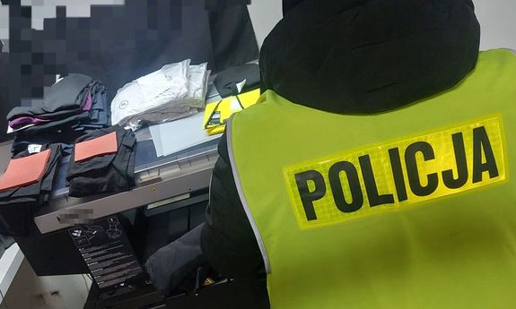 policjanci w trakcie zabezpieczenia podrobione odzieży markowych marek