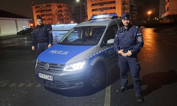 policjant stoi przy radiowozie