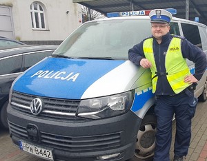 policjant stoi przy radiowozie