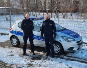 dwaj policjanci przy radiowozie