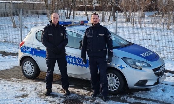 dwaj policjanci przy radiowozie