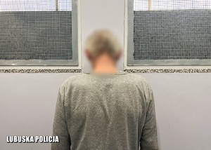 Mężczyzna w pomieszczeniu dla osób zatrzymanych - widok z tyłu