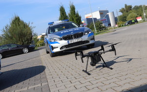 dron stojący na drodze przed radiowozem