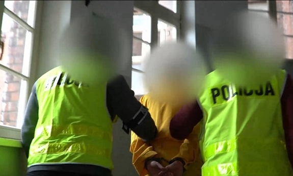 policjanci prowadzą zatrzymanego mężczyznę