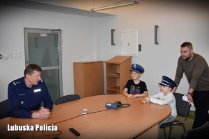 umundurowany policjant wraz z gośćmi na sali odpraw