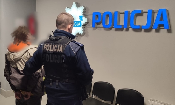 policjant z zatrzymanym zakutym w kajdanki