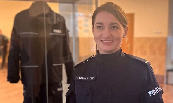 policjantka w pomieszczeniu, w tle gablota z mundurem policyjnym