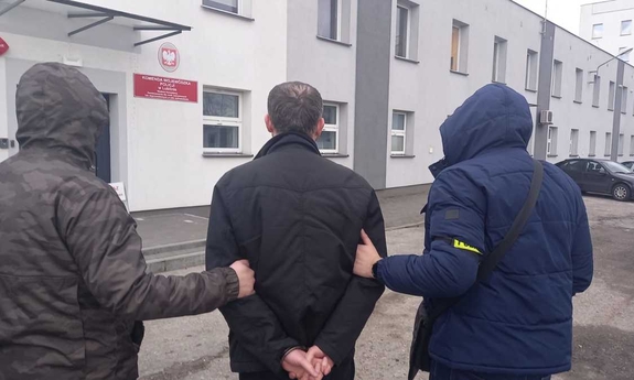 policjanci prowadzą zatrzymanego mężczyznę do jednostki Policji