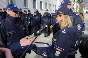 policjantka wręcza policjantowi dokument