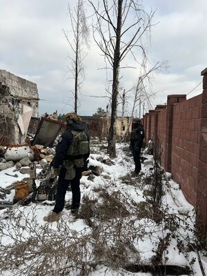 policjanci sprawdzają zniszczony budynek z użyciem robota