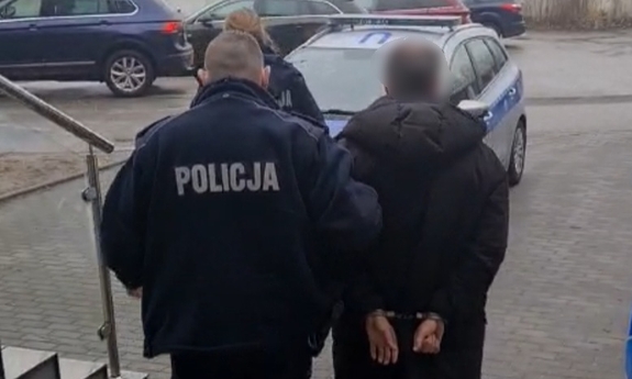 policjant prowadzi zatrzymanego