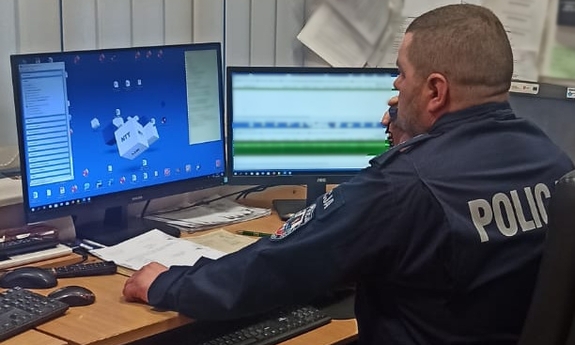 policjant dyżurny siedzi przy stanowisku pracy