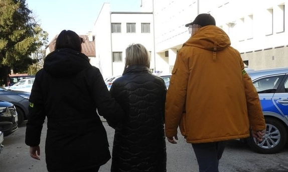 zatrzymana kobieta prowadzona przez dwoje policjantów