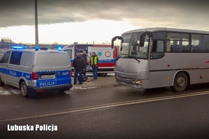 Policjant przy radiowozie i autokarze
