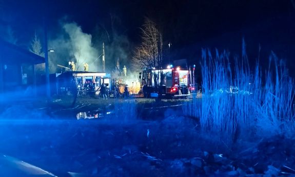 na miejscu zdarzenia widać płonący budynek, funkcjonariuszy i wóz straży pożarnej