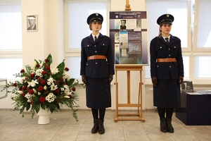 dwie kobiety w mundurach Policji Państwowej stoją przy sztaludze z plakatem