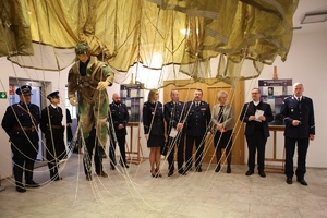 uczestnicy seminarium oglądają wystawę w Muzeum Policji, na pierwszym planie element wystawy — spadochroniarz wisi na spadochronie