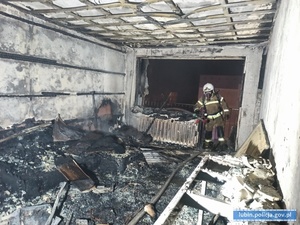 Na zdjęciu strażak stojący w spalonym pomieszczeniu