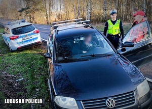 Policjant ruchu drogowego i medycy przy poszkodowanym kierującym