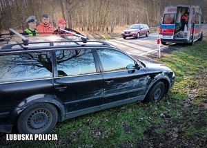 Policjant ruchu drogowego i medycy przy poszkodowanym kierującym