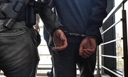 policjant prowadzi zatrzymanego nastolatka w kajdankach
