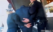 policjanci z zatrzymanym mężczyzną zakutym w kajdanki