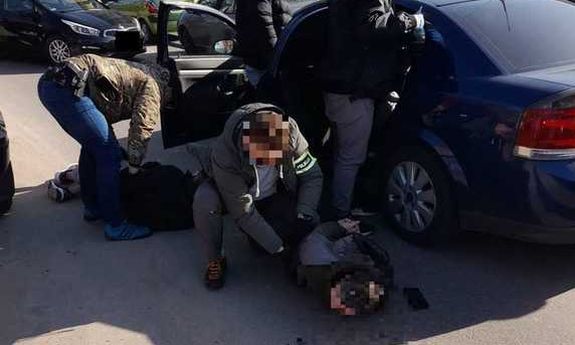 policjanci skuwają zatrzymanych