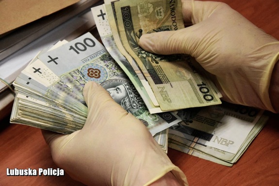 widoczne dłonie osoby, która trzyma w rękach i liczy banknoty 100 złotowe