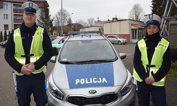 umundurowana policjantka i policjant stoją przy radiowozie