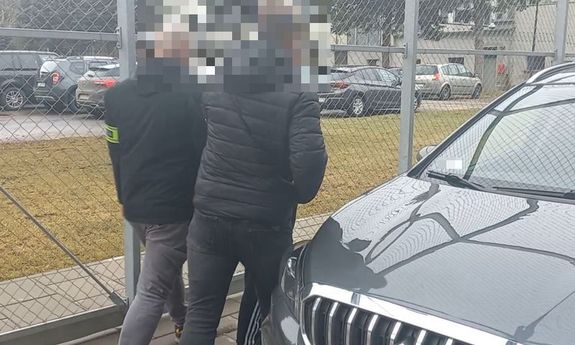 policjant prowadzi zatrzymanego