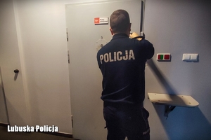 Policjant zamyka drzwi na zamek w pokoju zatrzymań