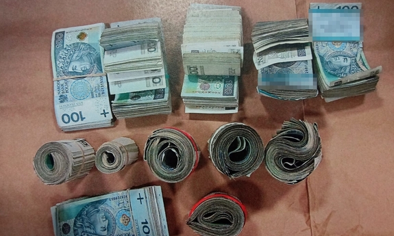 zabezpieczona gotówka w banknotach 100 złotowych, częśc zwinięta w rulon