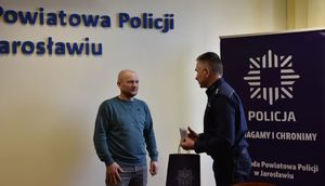 I Zastępca Komendanta wręcza mężczyźnie podarunek