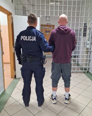 umundurowany policjant z zatrzymanym mężczyzną