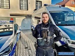 umundurowany policjant sierżant Piotr Czycz stojący przy radiowozie