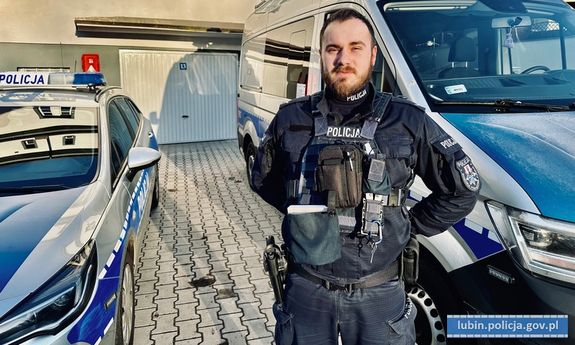 umundurowany policjant sierżant Piotr Czycz stojący przy radiowozie