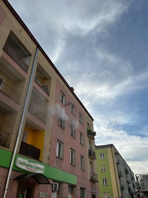 budynek przy ulicy Żółkiewskiego,  z okna na drugim piętrze wydobywa się dym