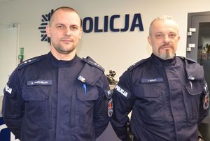 dwaj umundurowani policjanci pozują do zdjęcia