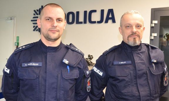 dwaj umundurowani policjanci pozują do zdjęcia