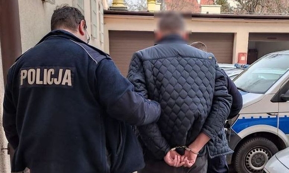 dwaj nieumundurowani policjanci prowadzą zatrzymanego