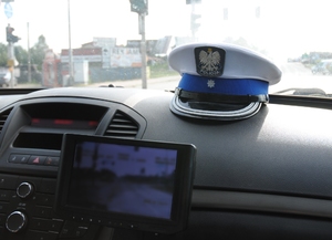 wnętrze pojazdu, na desce rozdzielczej leży czapka policyjna